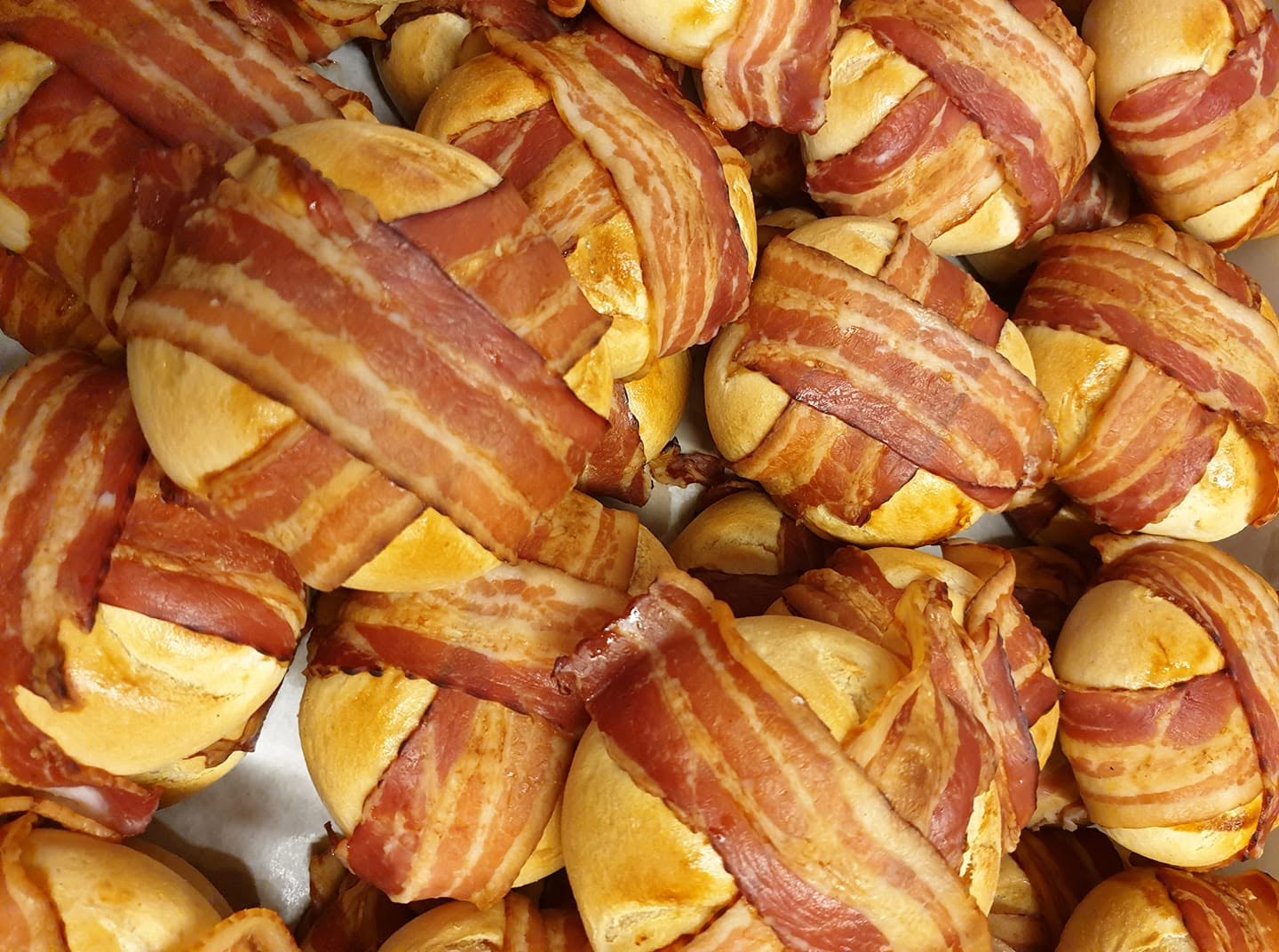 Versgebakken broodjes omwikkeld met spek, net uit de oven