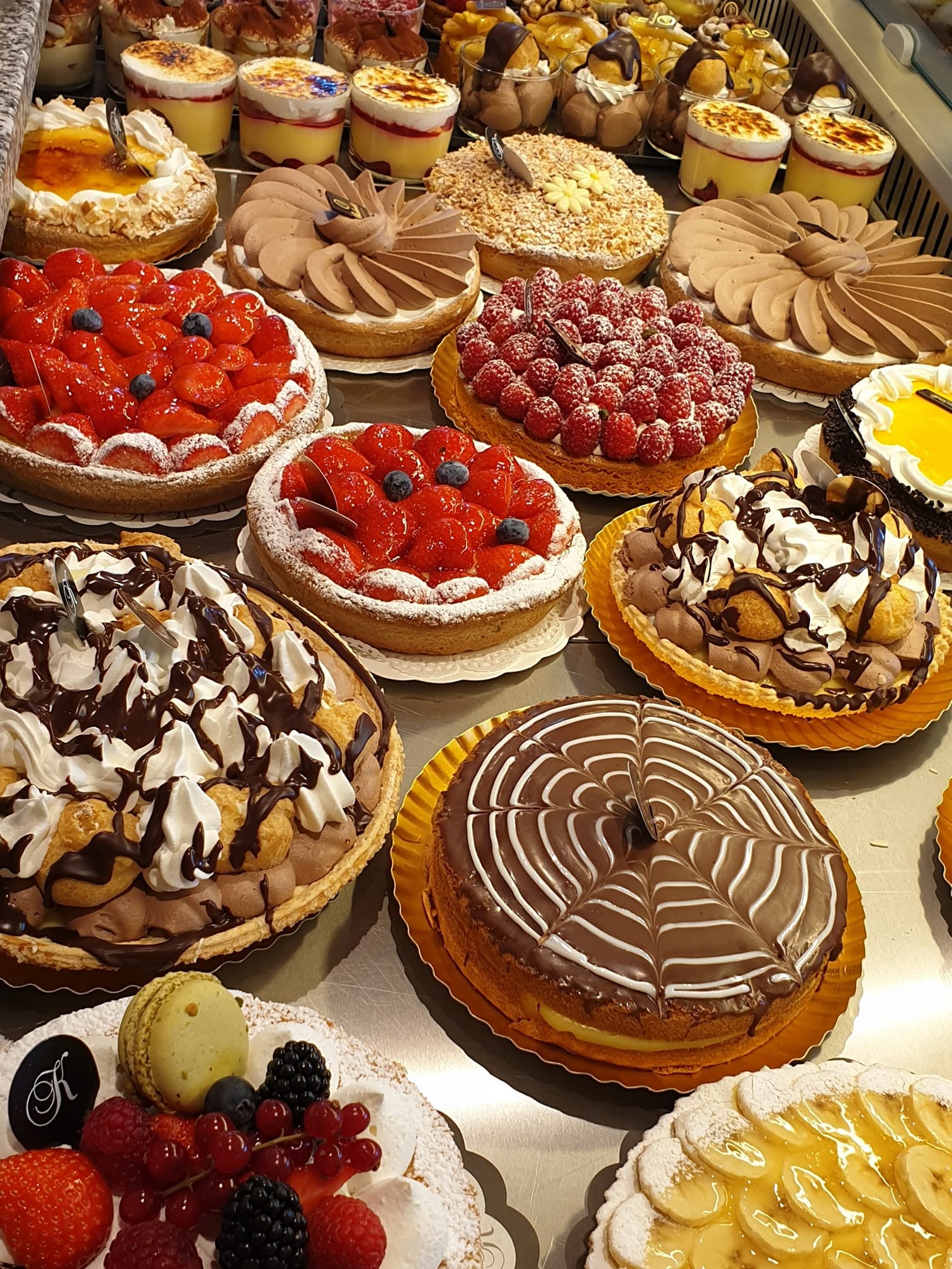 De toonbank met aardbeientaarten, frambozentaart, chocolademoussetaarten en een taartje met het chocoladeplaatje met de K van Kathleen